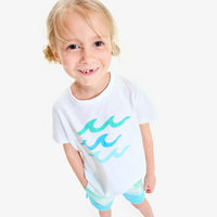 A girl smiling at the camera wearing a sea graphic t-shirt