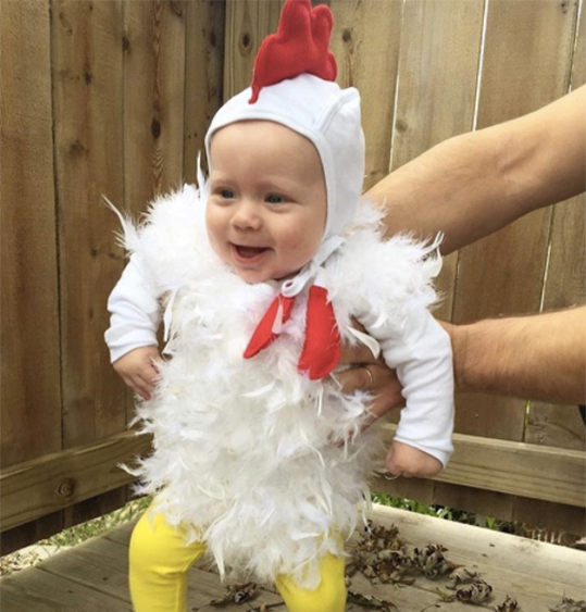 Chicken: A baby wearing a white top and yellow bottom with chicken feathers on the top