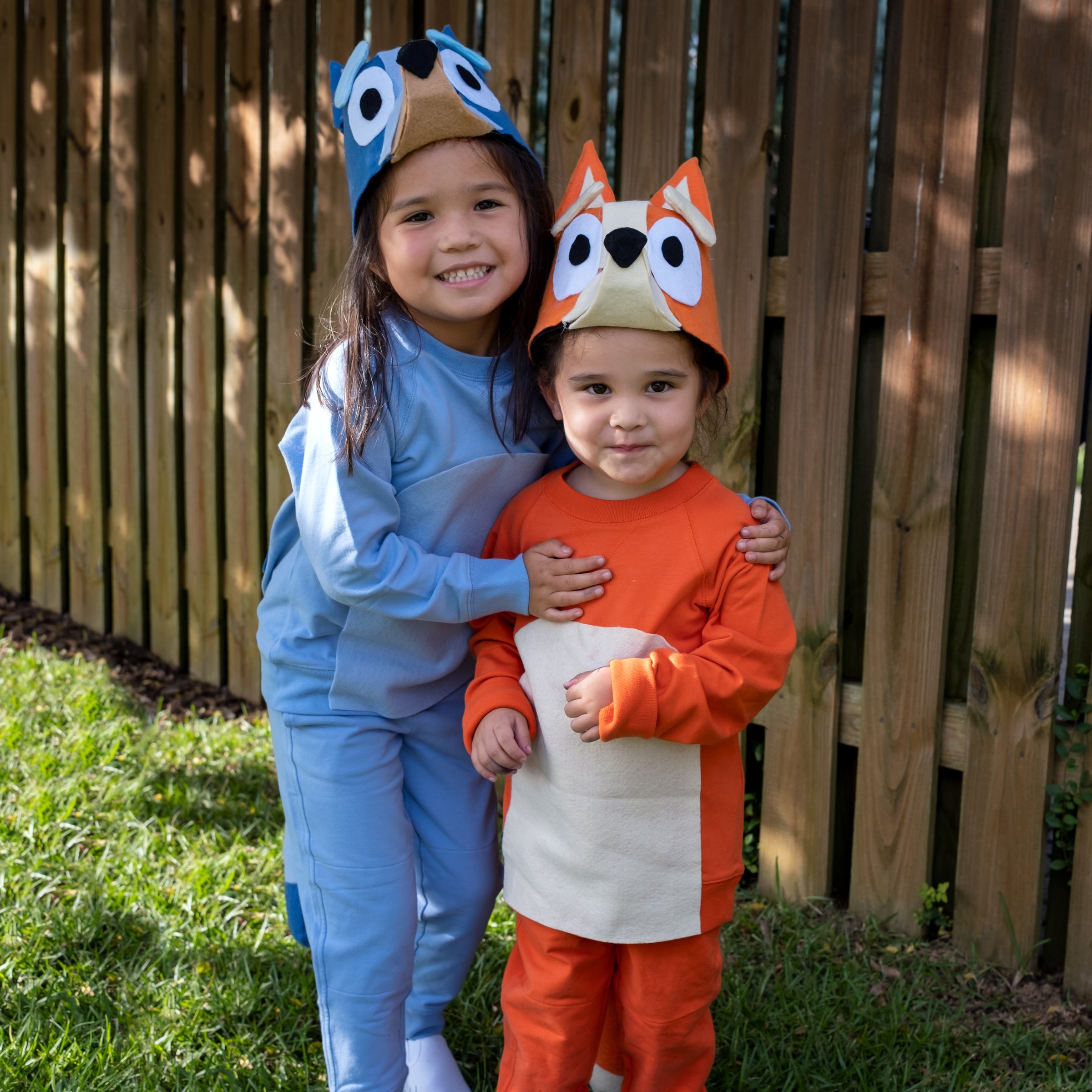 Bluey and Bingo: Two kids wearing matching blue and orange DIY Halloween costumes, dressed up as cartoon characters Bluey and Bingo.