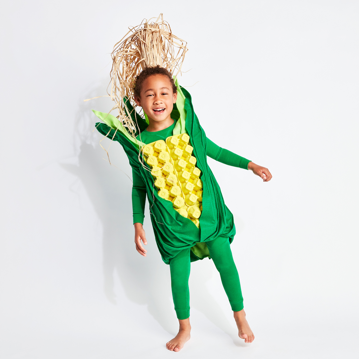 Corn (Kid): A kid wearing a green outfit with DIY corn embellishments