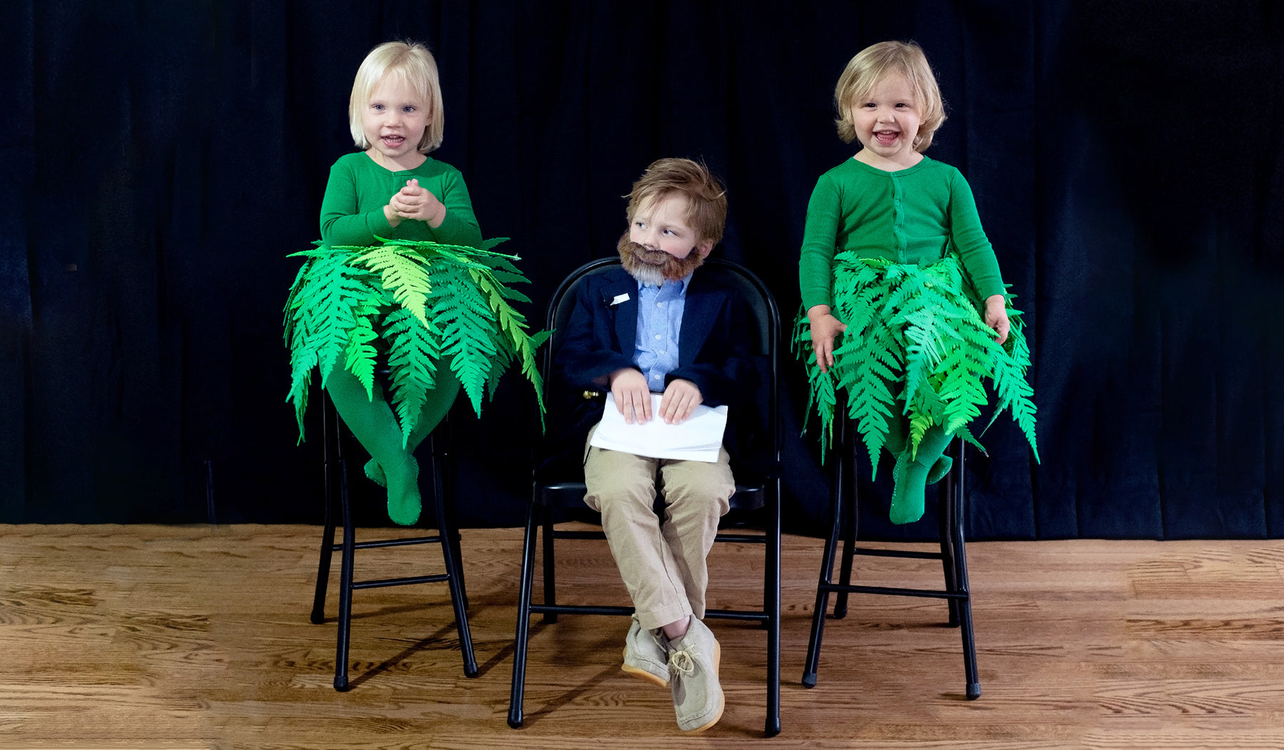 three children dressed in a DIY halloween costume of zach galifianakis in between two ferns