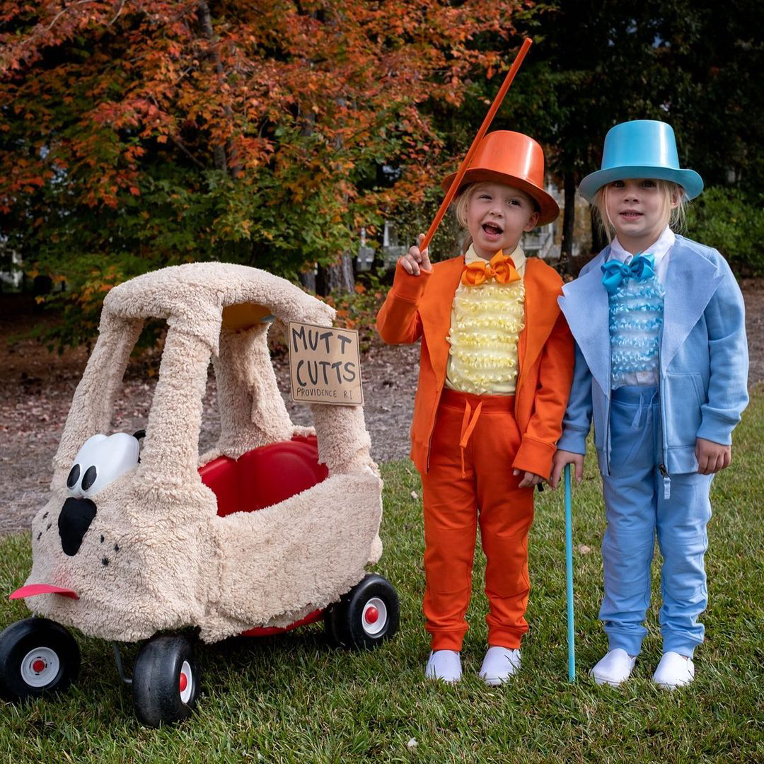 Dumb and Dumber: Two children, one wearing an orange outfit and another wearing a blue outfit, both with top hats and canes. 