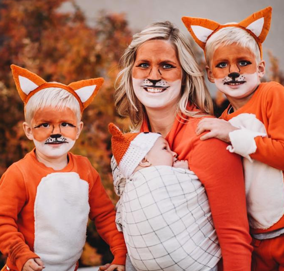 Fox Family: Two kids and a baby all wearing orange outfits and fox ear headbands.