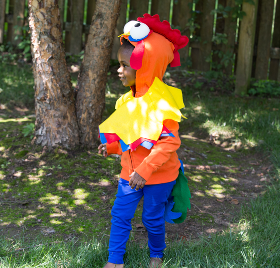 Hei Hei (Kid): A baby in a pink top and yellow bottom with Hei Hei inspired DIY embellishments