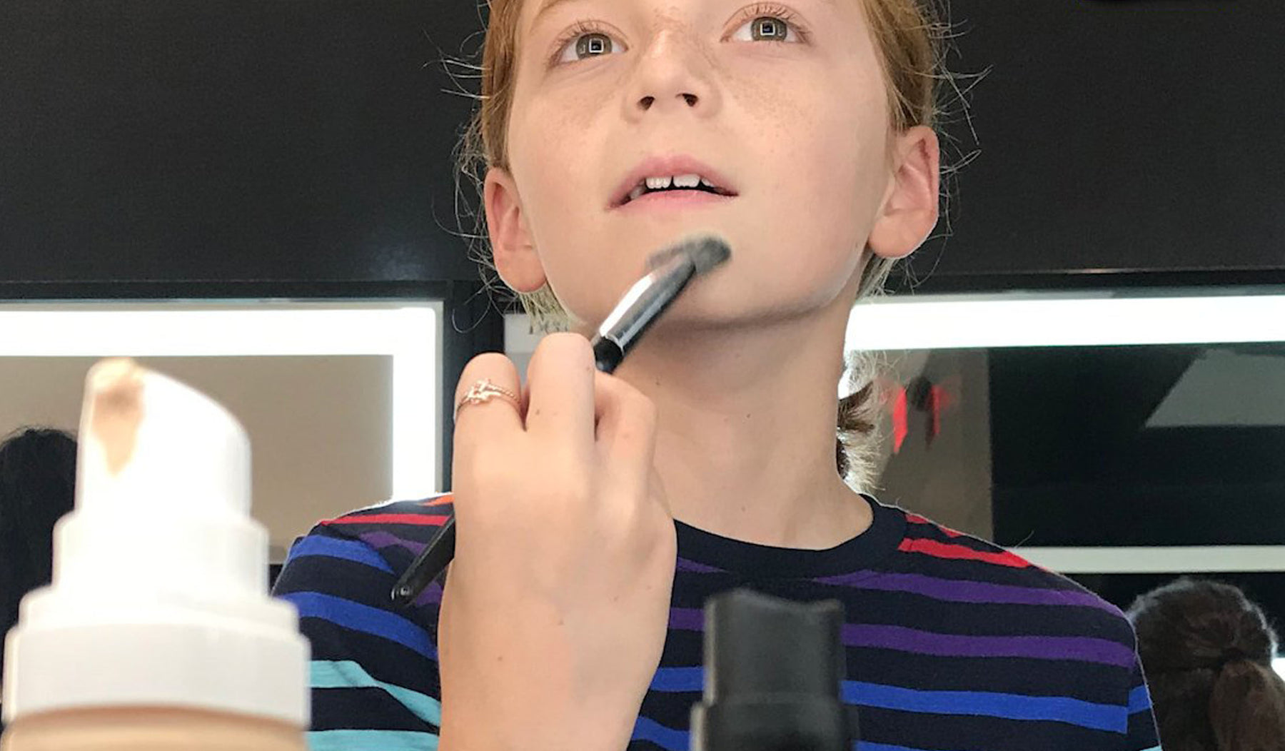 Boy putting on makeup at Sephora