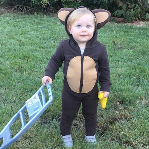 Monkey: A child wearing a brown babysuit with animal ears attached to the hood