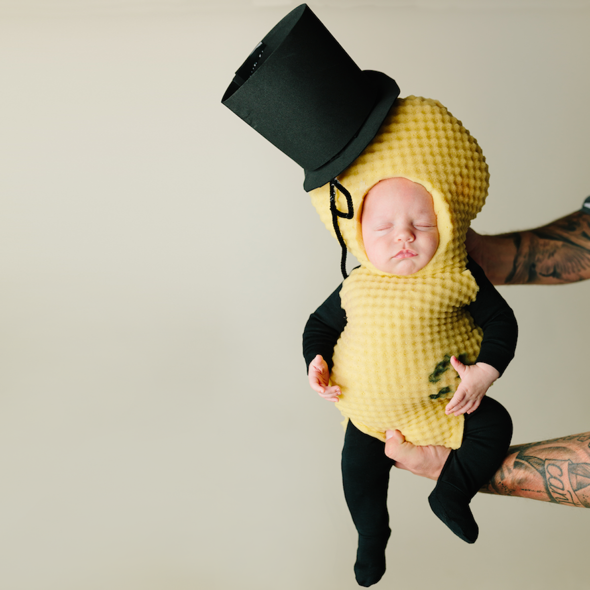 Mr. Peanut: A baby wearing a black babysuit with a yellow crocheted "peanut" costume overtop. 