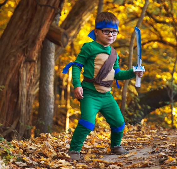 Ninja Turtle: A child wearing a green outfit with ninja turtle accessories