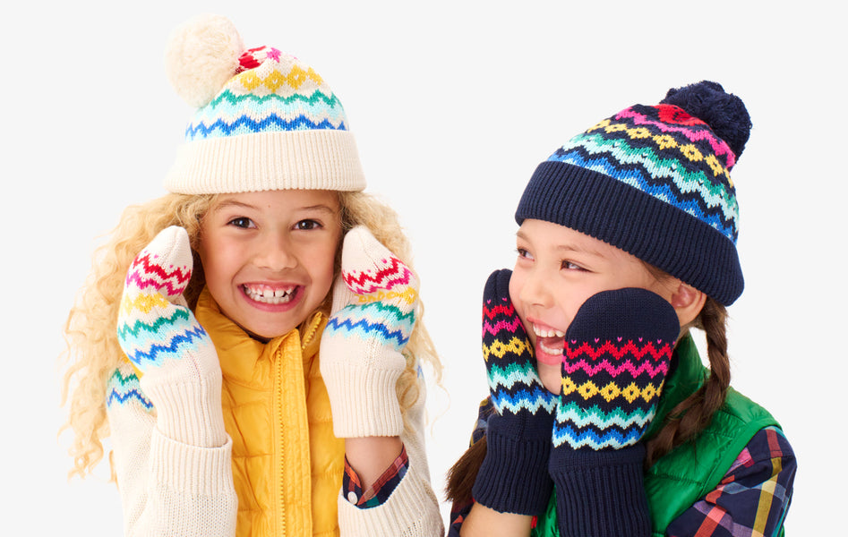 2 kids wearing our fair isle beanies and mittens smiling at the camera.