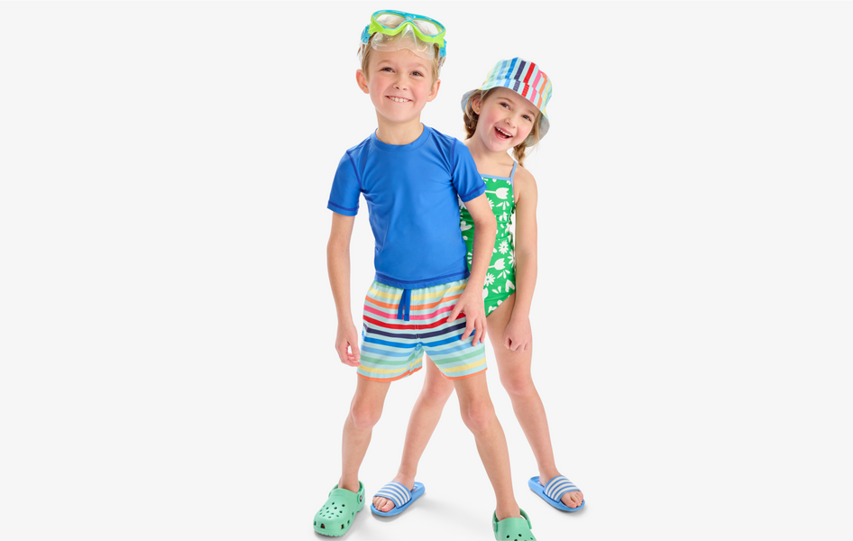 2 children standing in a row smiling wearing our new swim collection