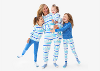 A family hugging each other wearing mix-and-match frosty fair isle and blueberry stripe PJs.