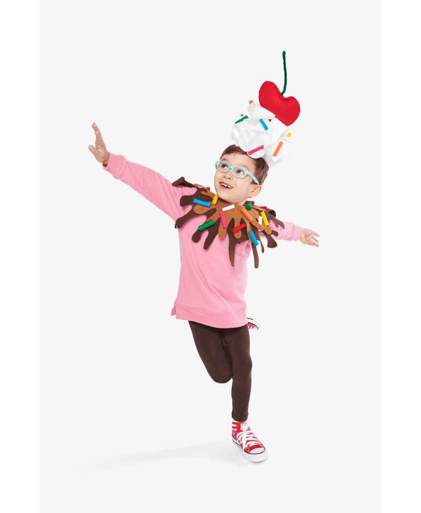 Final outcome of Ice Cream Sundae costume. The boy wears handmade whipped cream topped with a cherry on his head, and chocolate and caramel sauce bib with sprinkles around his shoulder. 