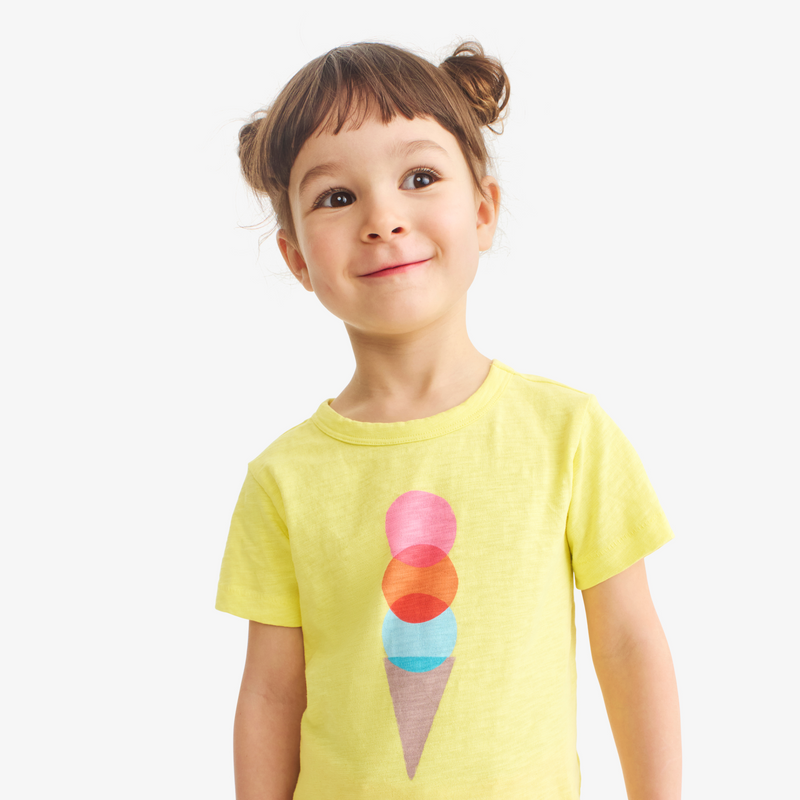 Child wearing a yellow t-shirt with an ice cream cone design on a white background