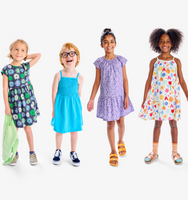 A line up of kids wearing new sping dresses in all different colors and prints.