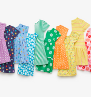 A laydown of 12 kids dresses showing the different prints and patterns in a rainbow order