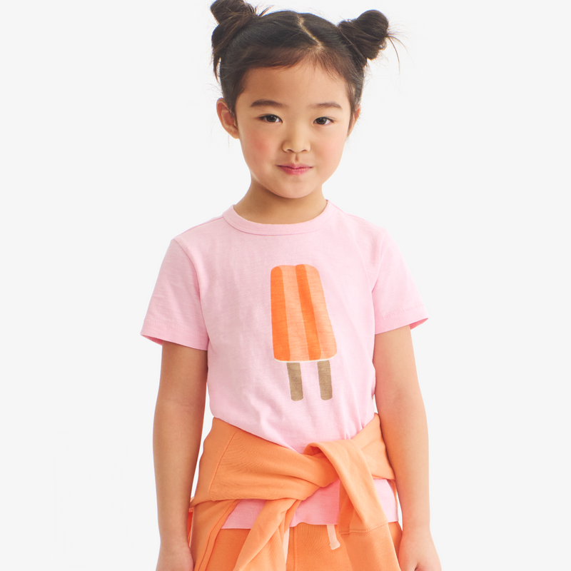Child wearing a pink t-shirt with an ice cream cone design on a white background
