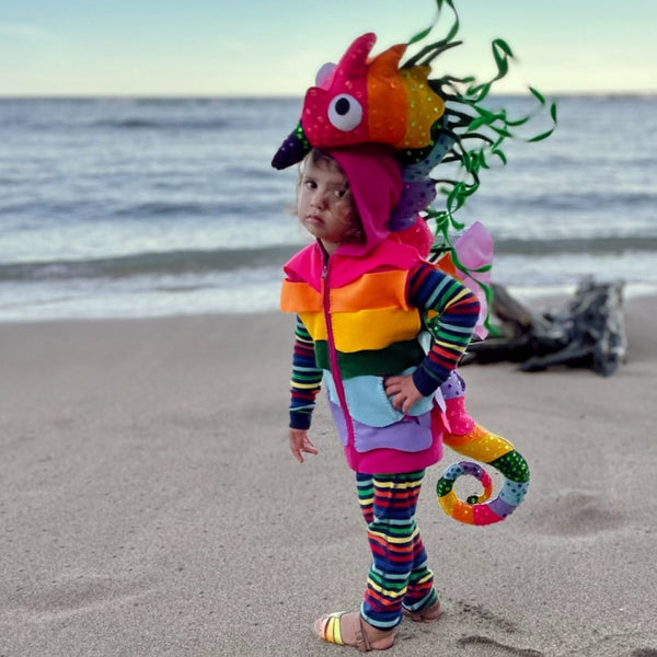 A kid wearing Primary's rainbow pajamas in a crayon ponyfish costume.
